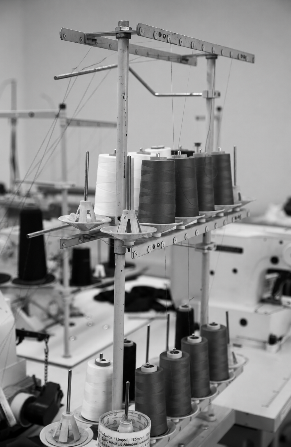 Garenklossen op een rek boven de naaimachines in het productieatelier